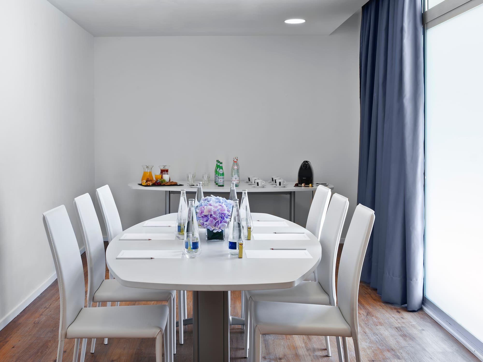 a room with white tables and chairs