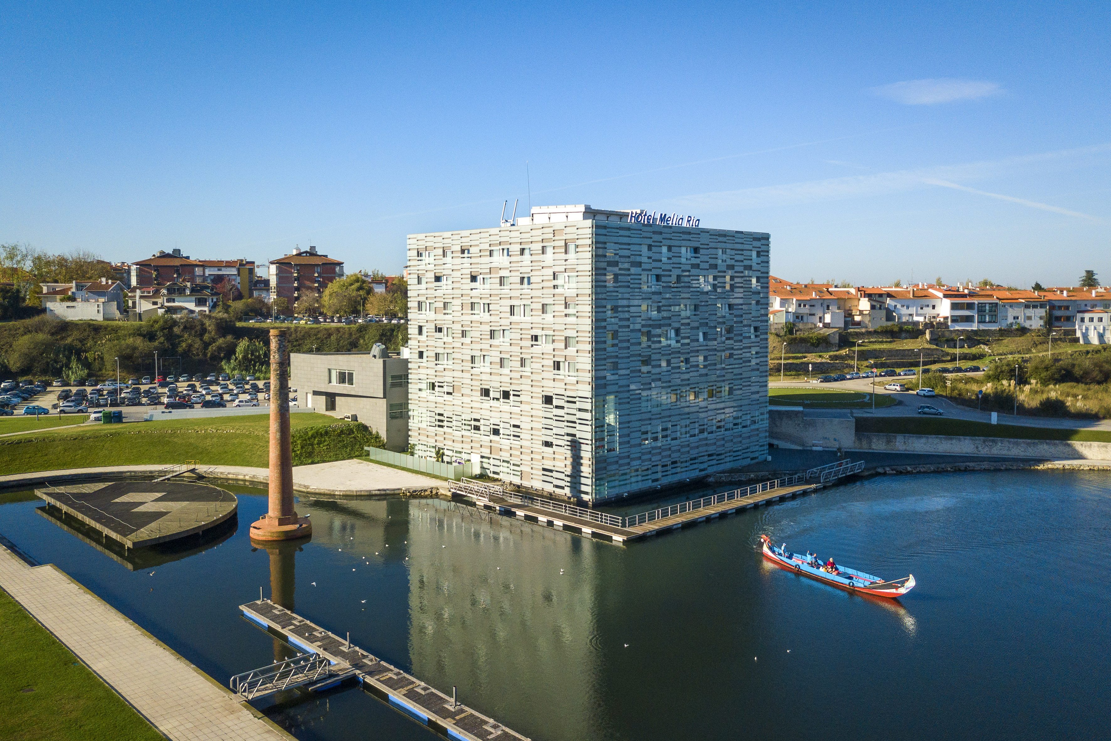 Hotel Meliá Ria and Moliceiro boat on Aveiro canal with historic chimney.