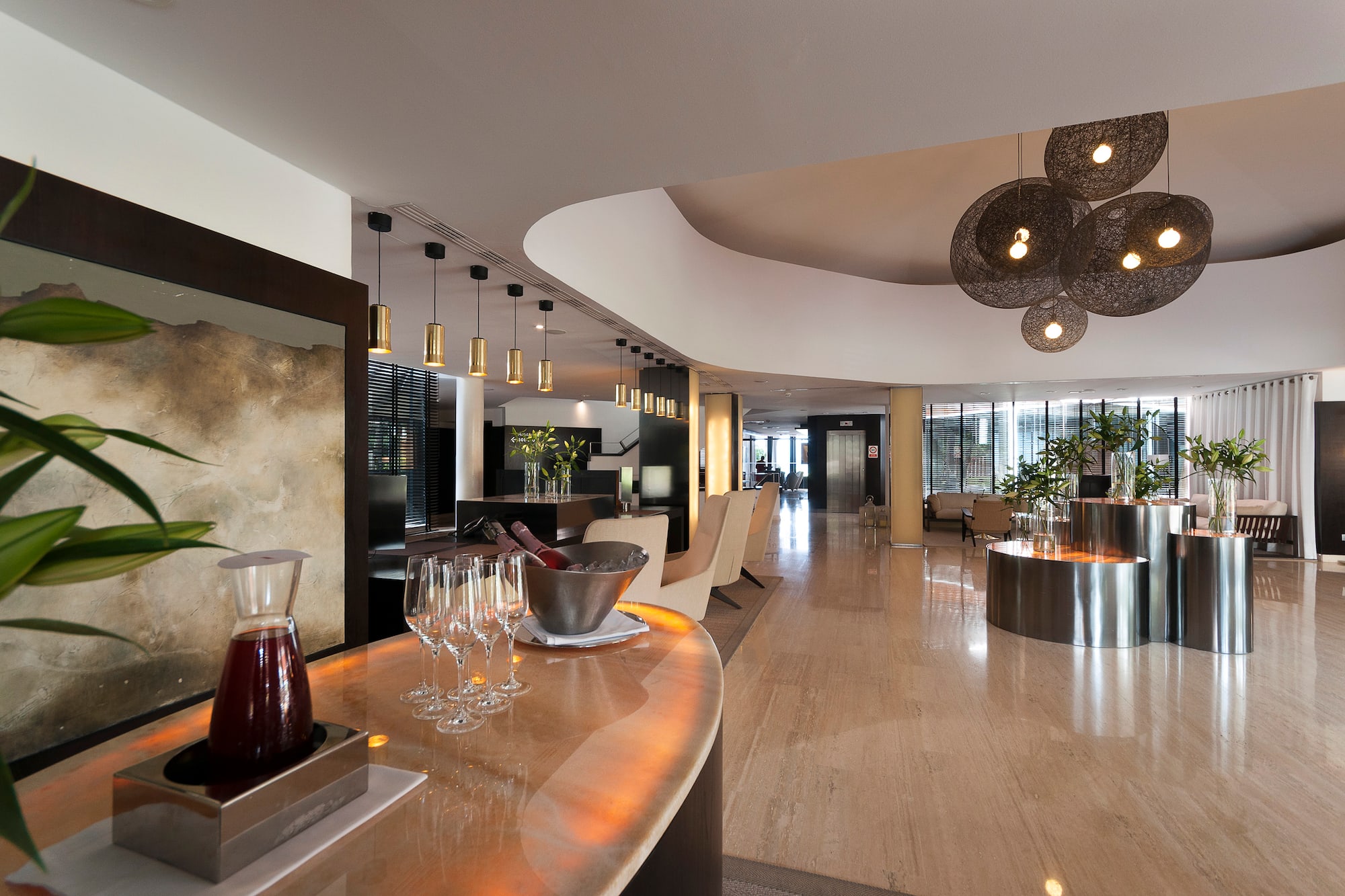 Luxury hotel lobby with a modern bar, elegant lighting, and marble floor.