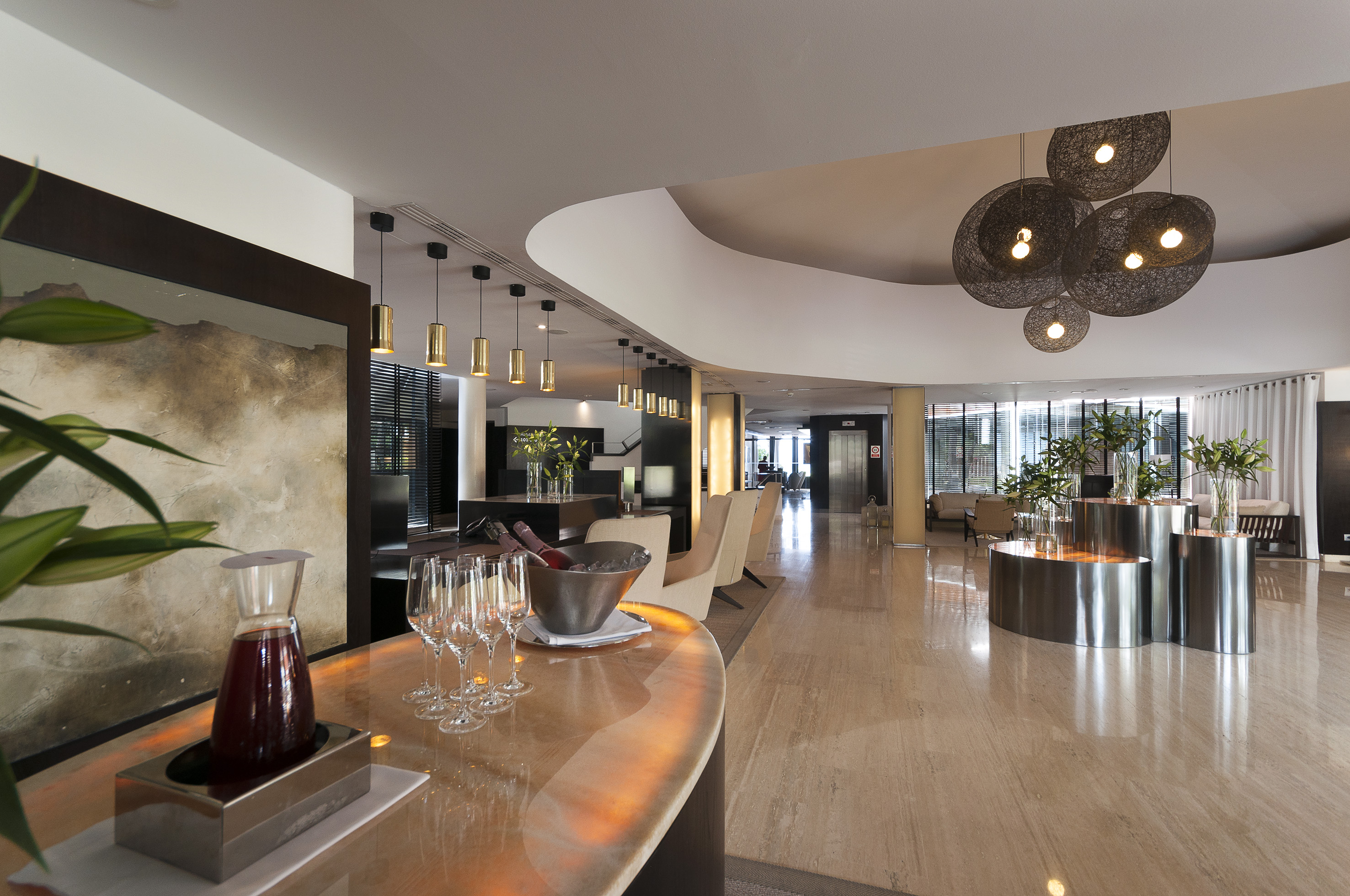 Luxury hotel lobby with a modern bar, elegant lighting, and marble floor.
