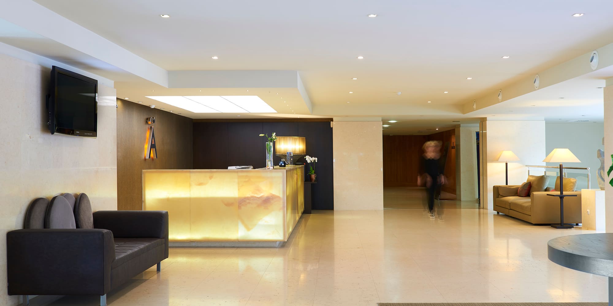 a lobby with a reception desk and a person walking