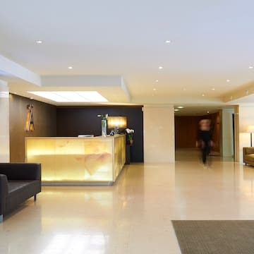 a lobby with a reception desk and a person walking