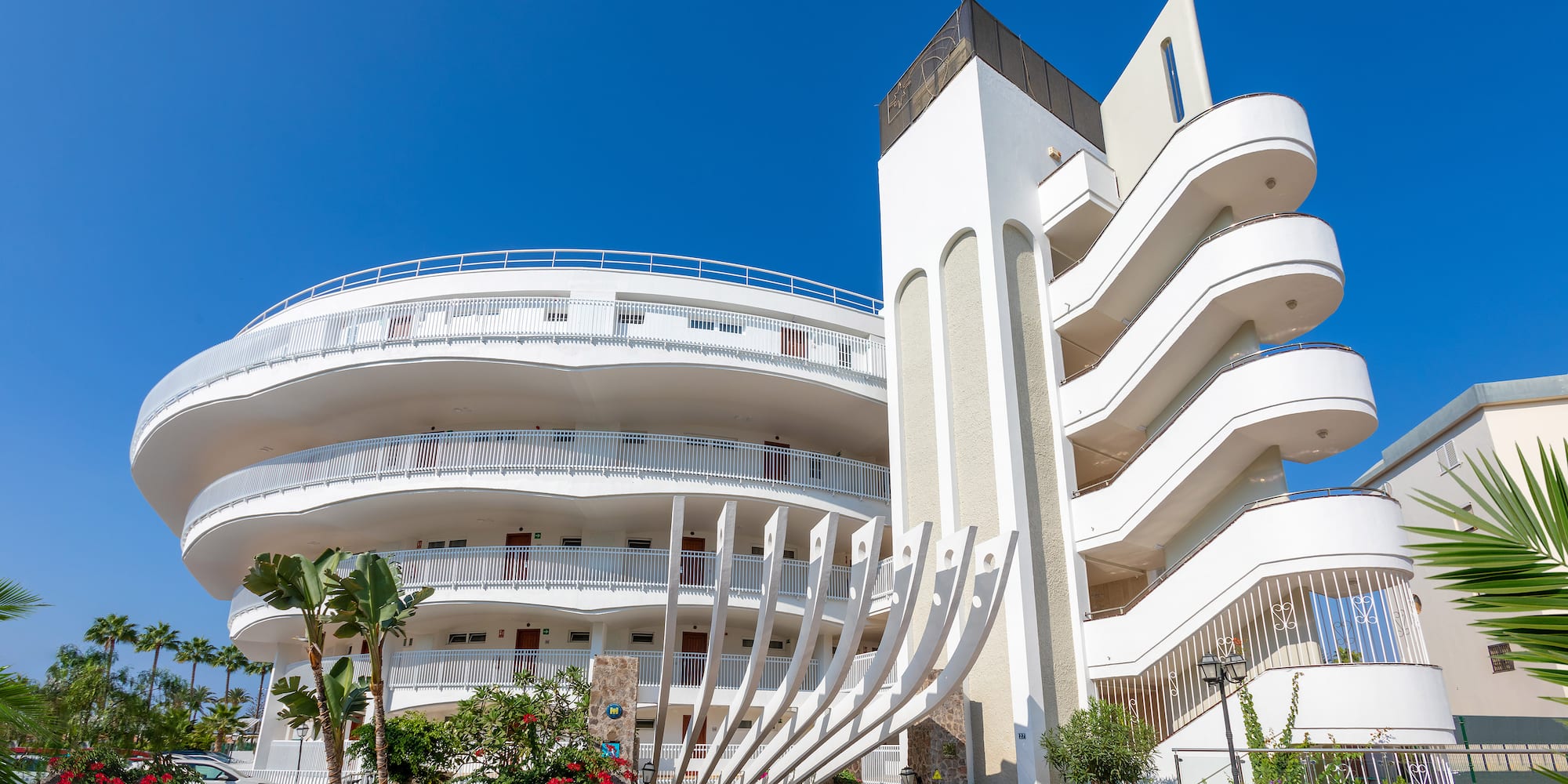 a building with a white wall and balconies