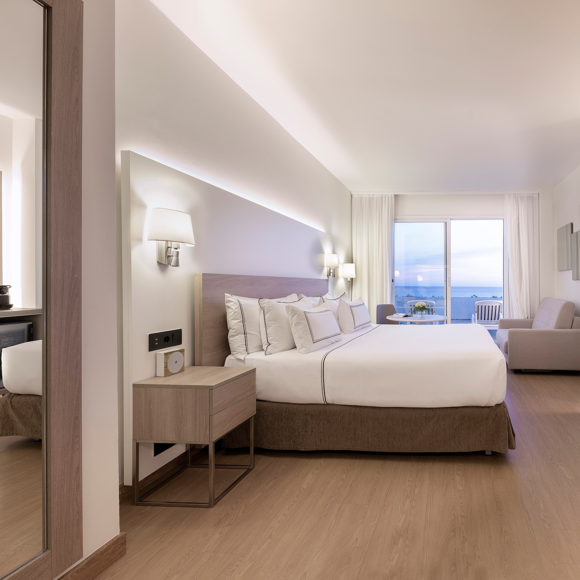 a bedroom with a large bed and a mirror