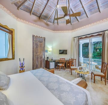 a room with a ceiling fan and a bed