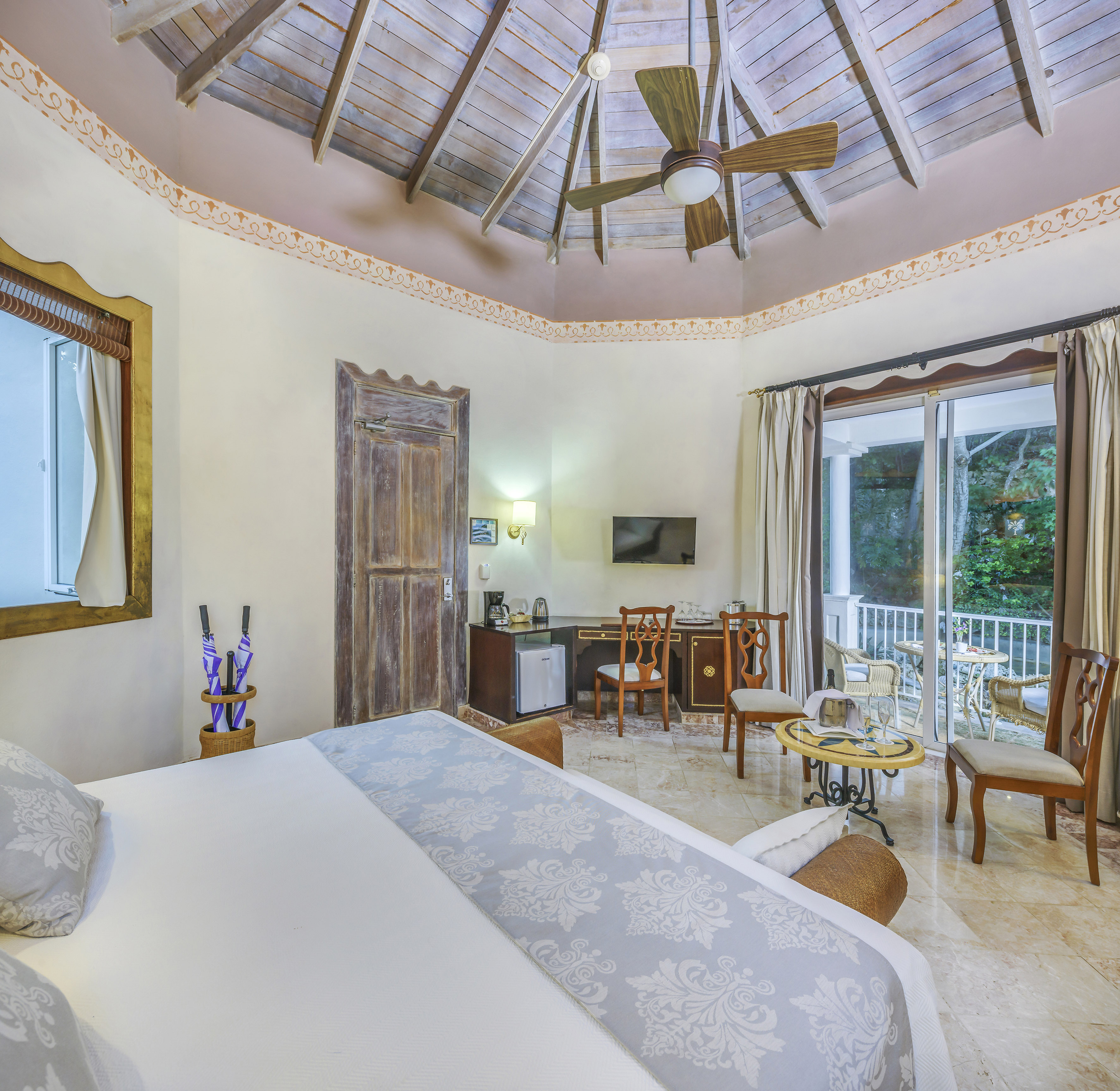 a room with a ceiling fan and a bed