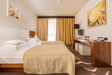 a room with two beds and a television