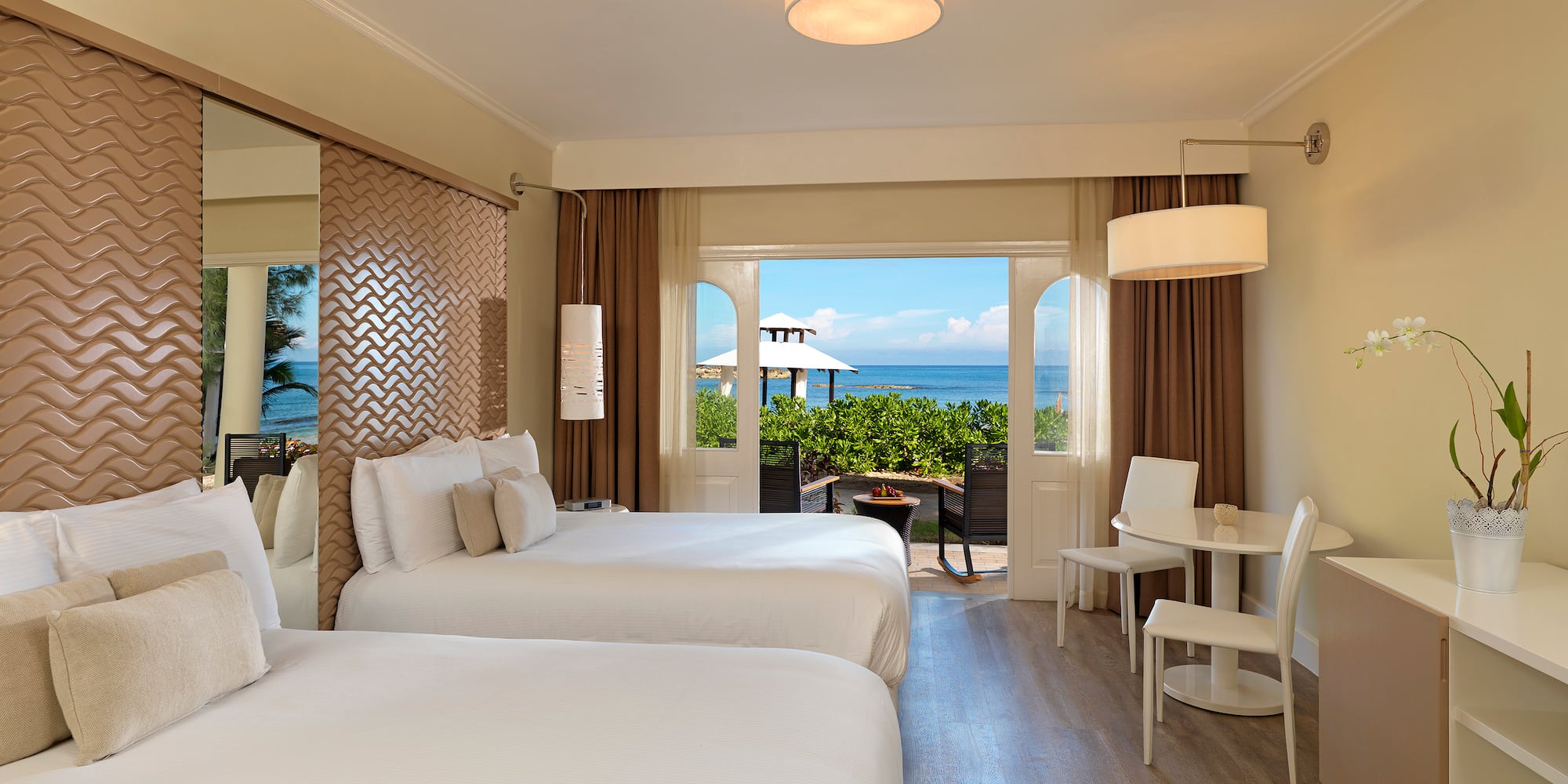 a room with two beds and a table and chairs