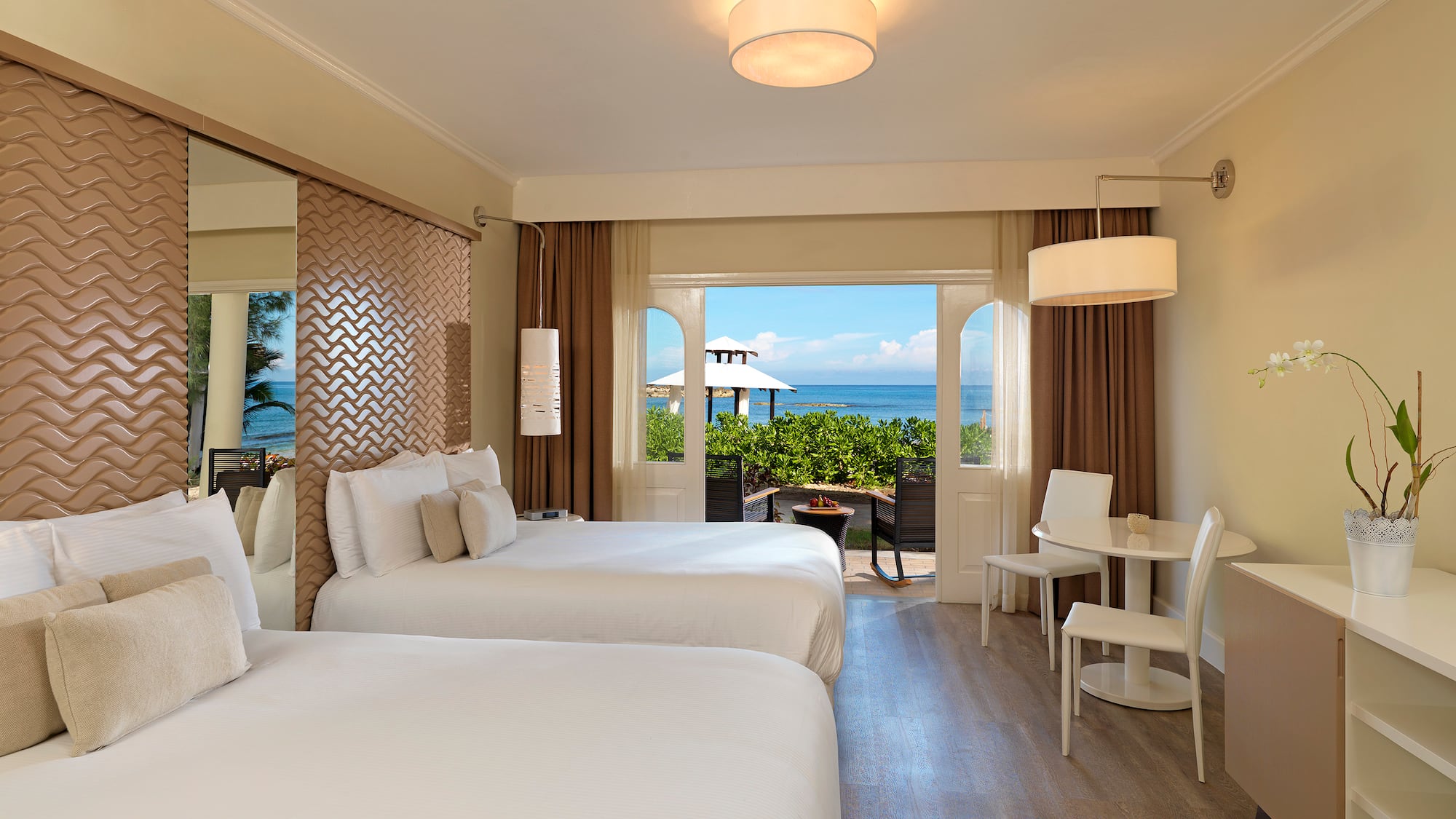 a room with two beds and a table and chairs