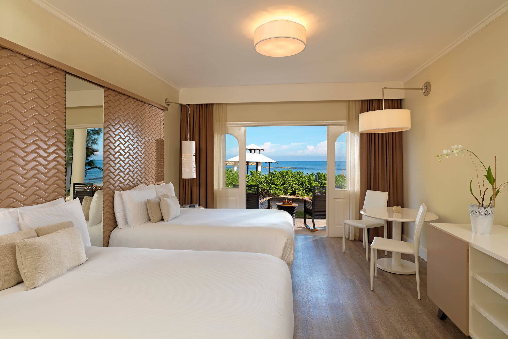 a room with two beds and a table and chairs