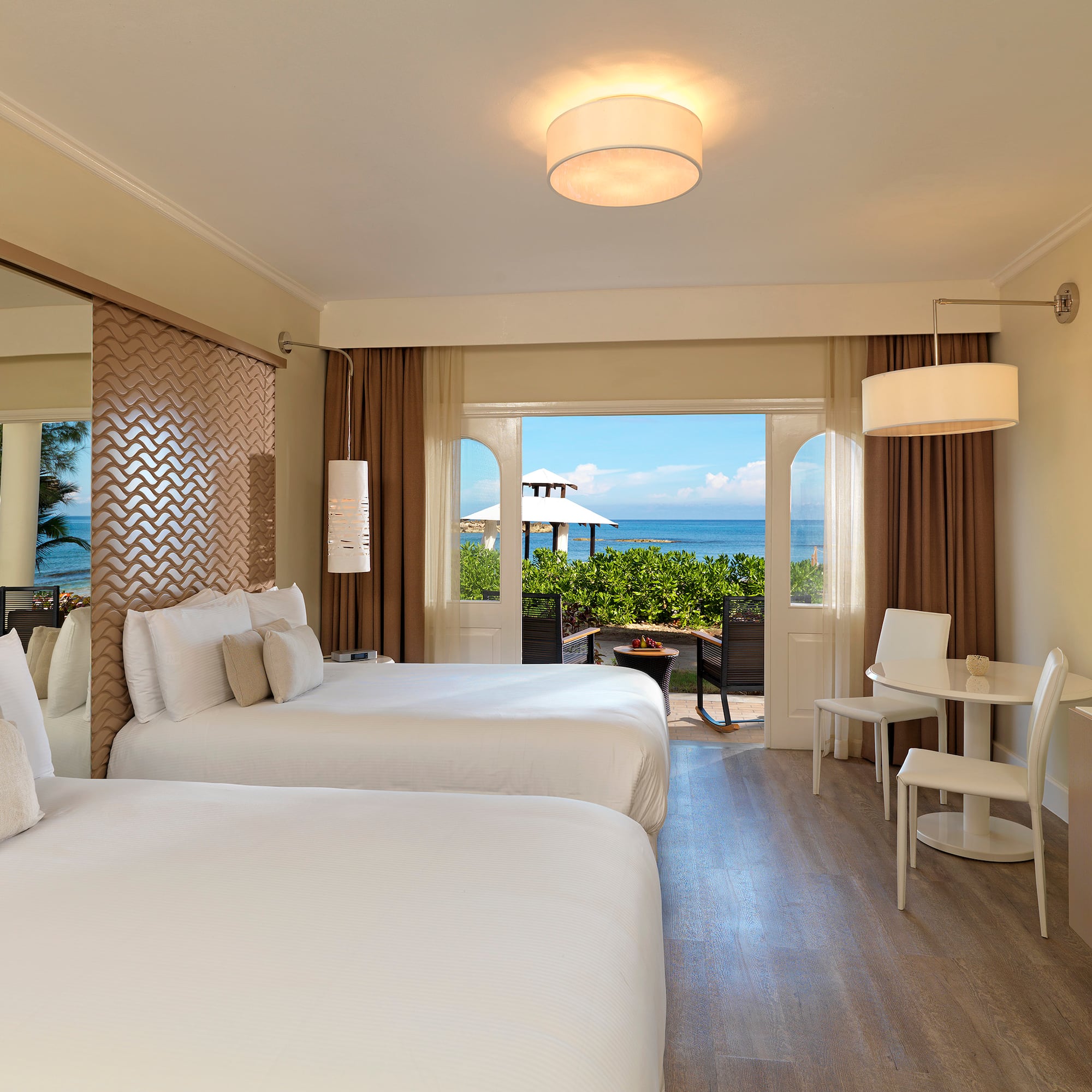 a room with two beds and a table and chairs