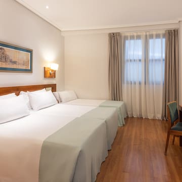 a room with two beds and a chair