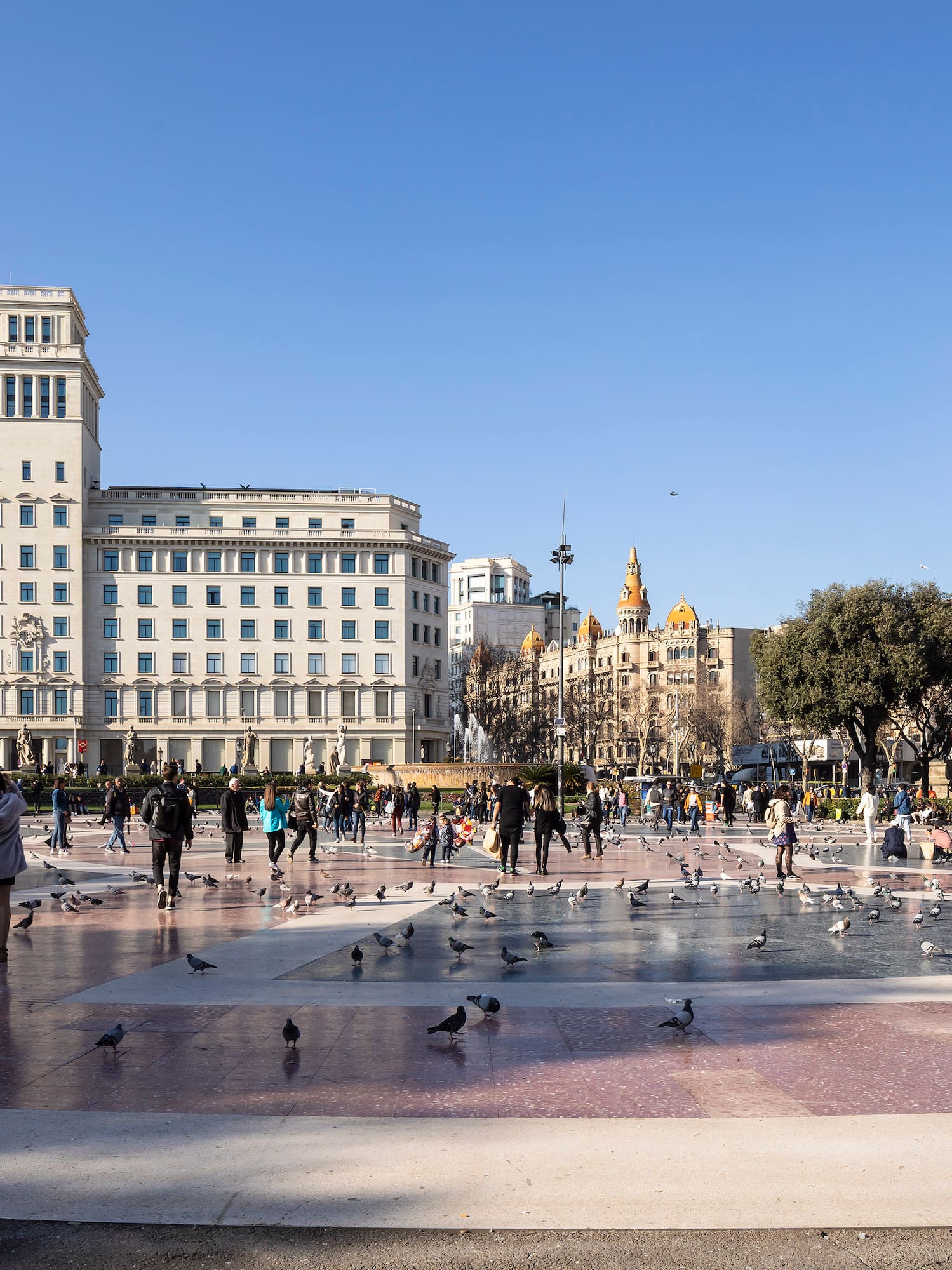 a group of people in a fountain with birds in the middle