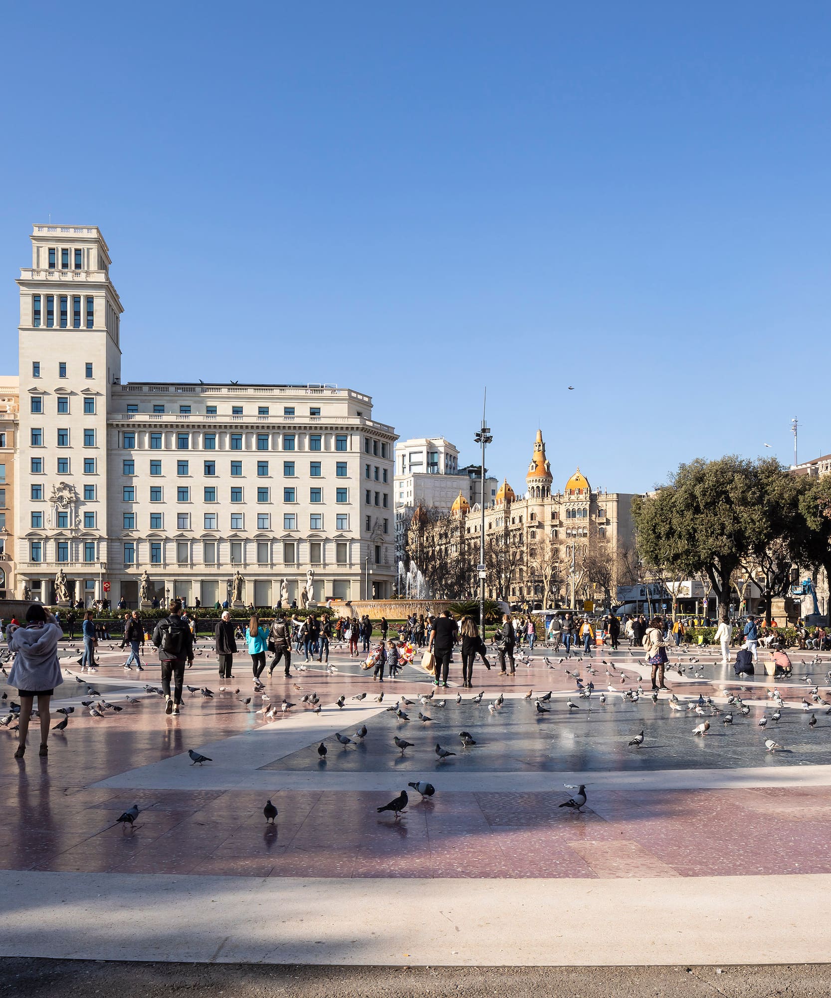 a group of people in a fountain with birds in the middle