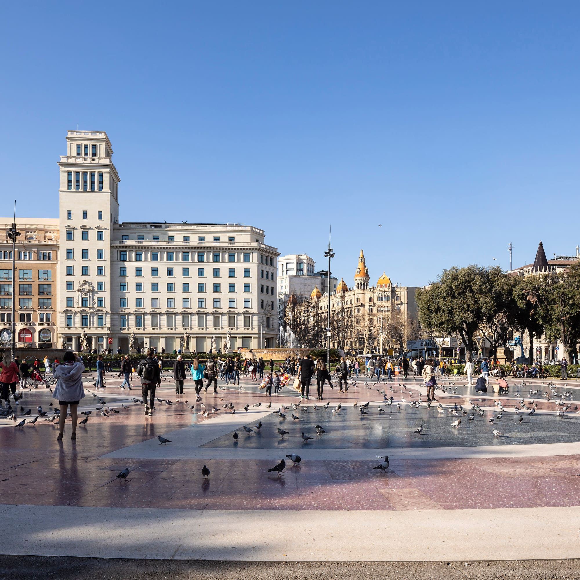 a group of people in a fountain with birds in the middle