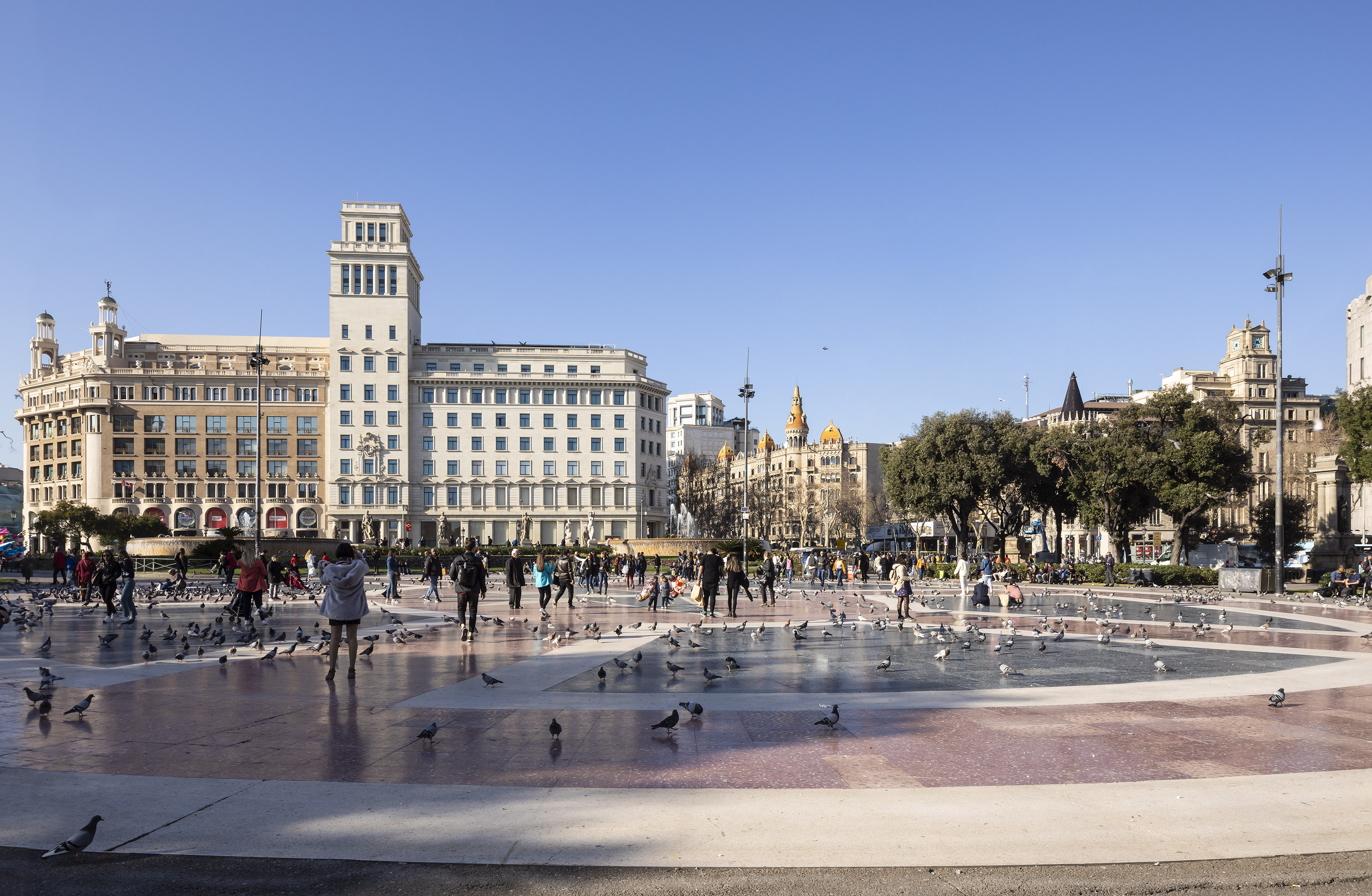 a group of people in a fountain with birds in the middle