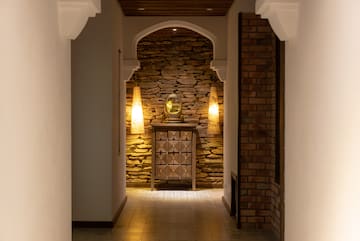 a hallway with a stone wall and a mirror