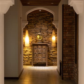 a hallway with a stone wall and a mirror