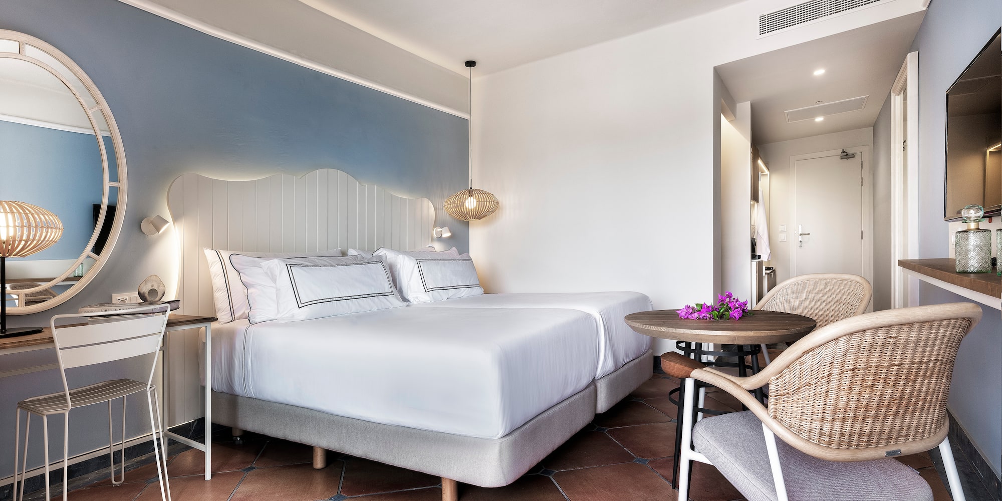 a room with a bed and chairs