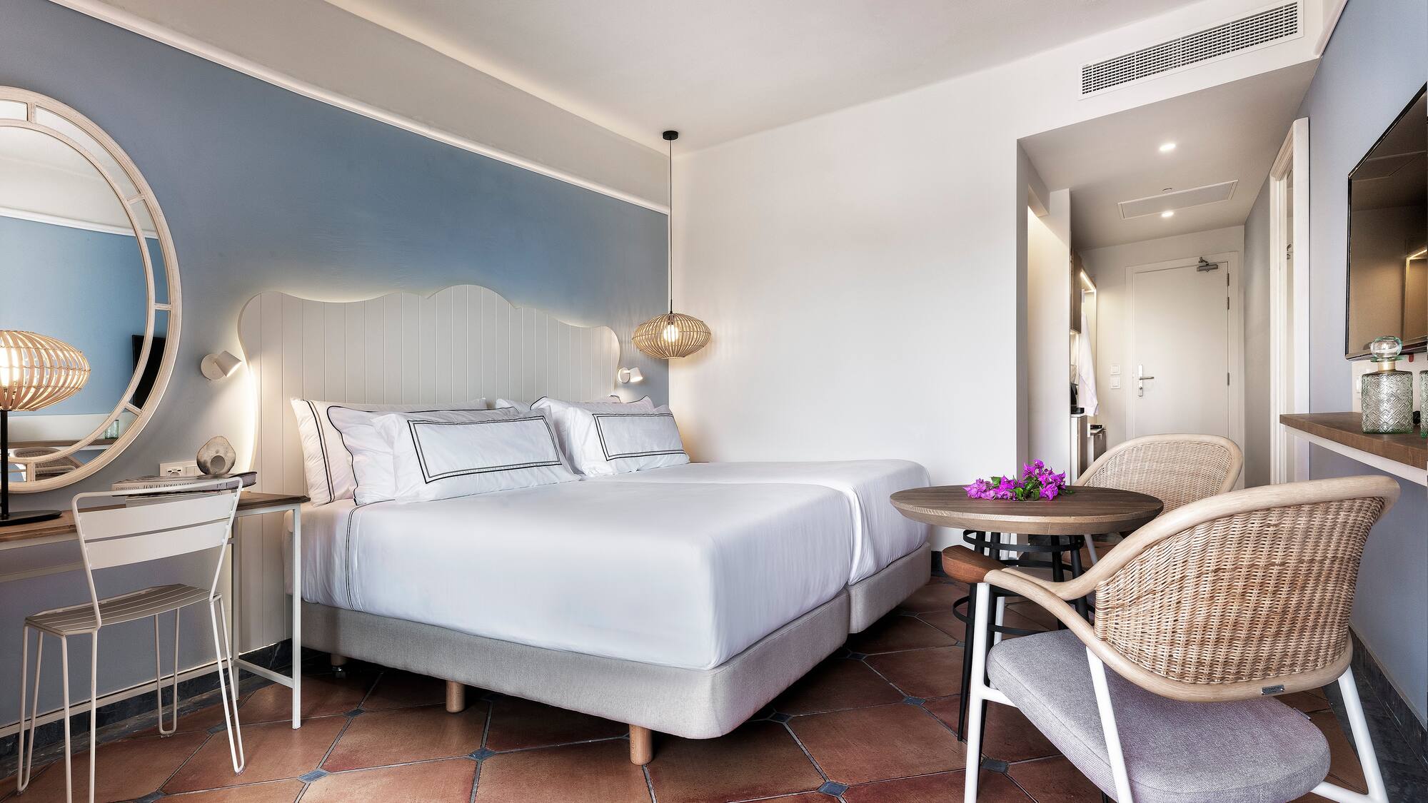 a room with a bed and chairs