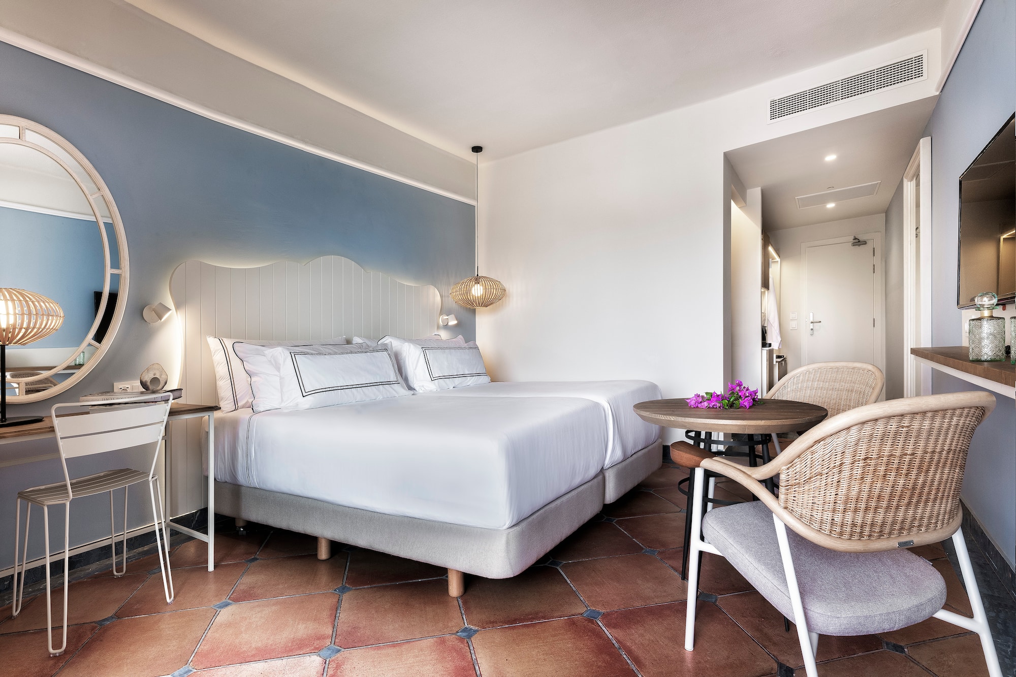 a room with a bed and chairs