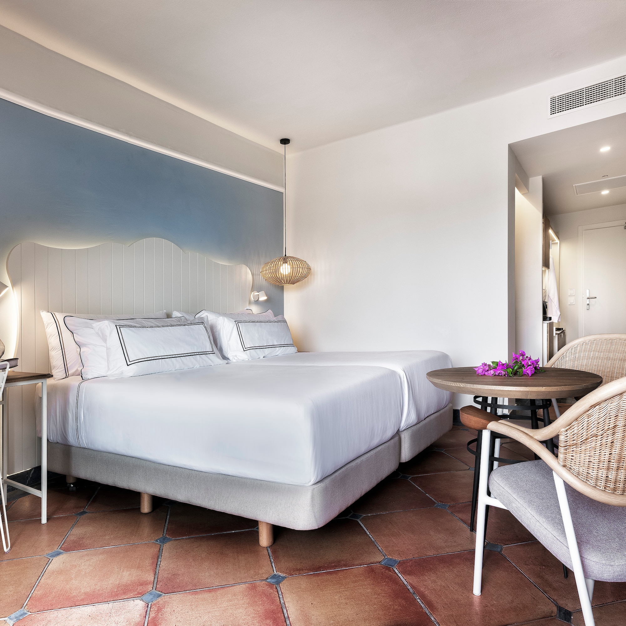 a room with a bed and chairs