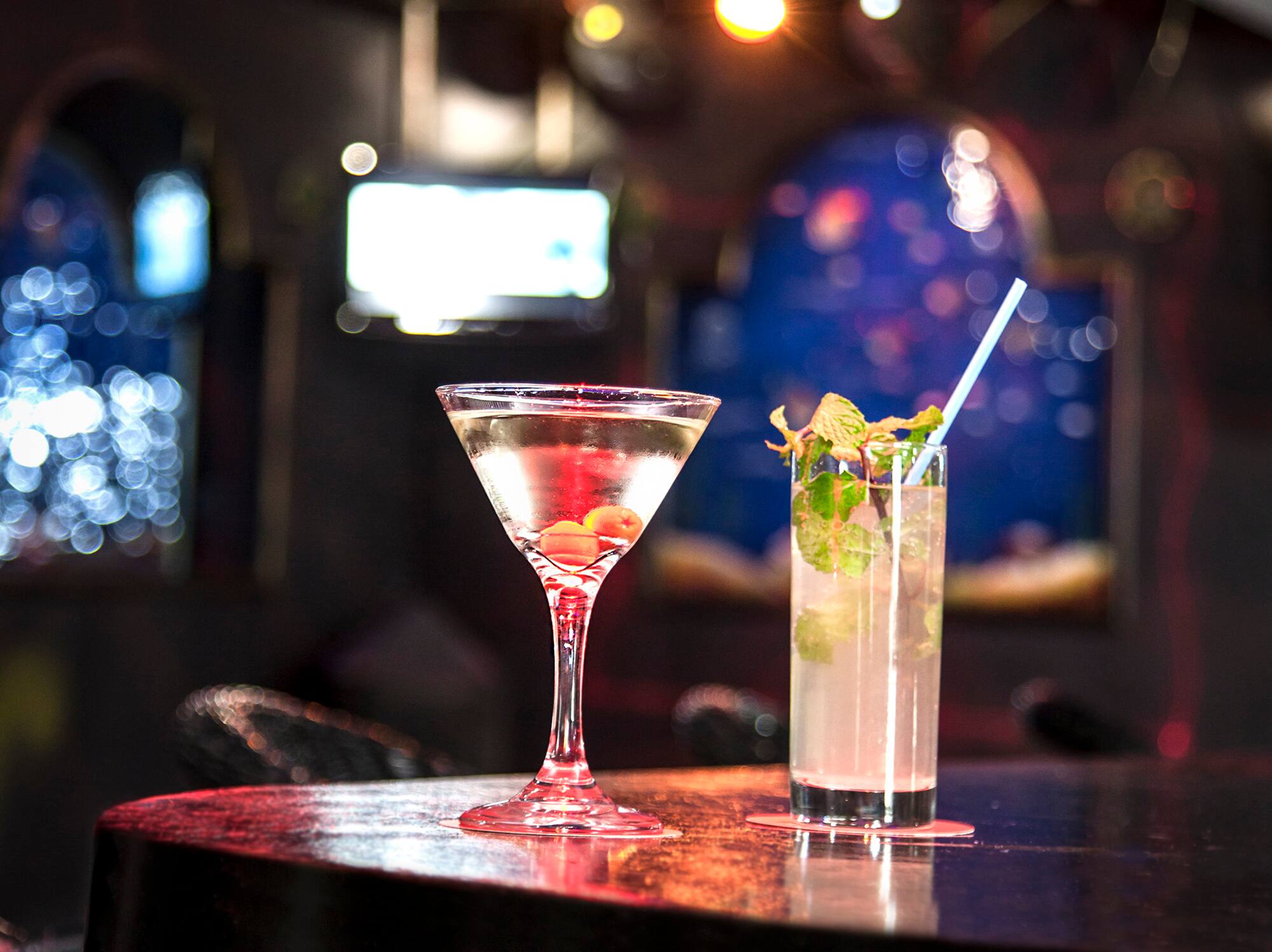 a glass of liquid and a drink on a bar