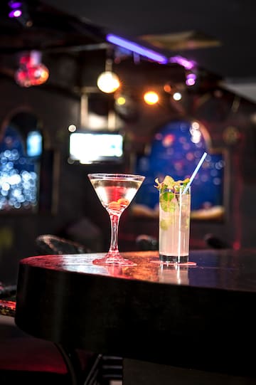 a glass of liquid and a drink on a bar