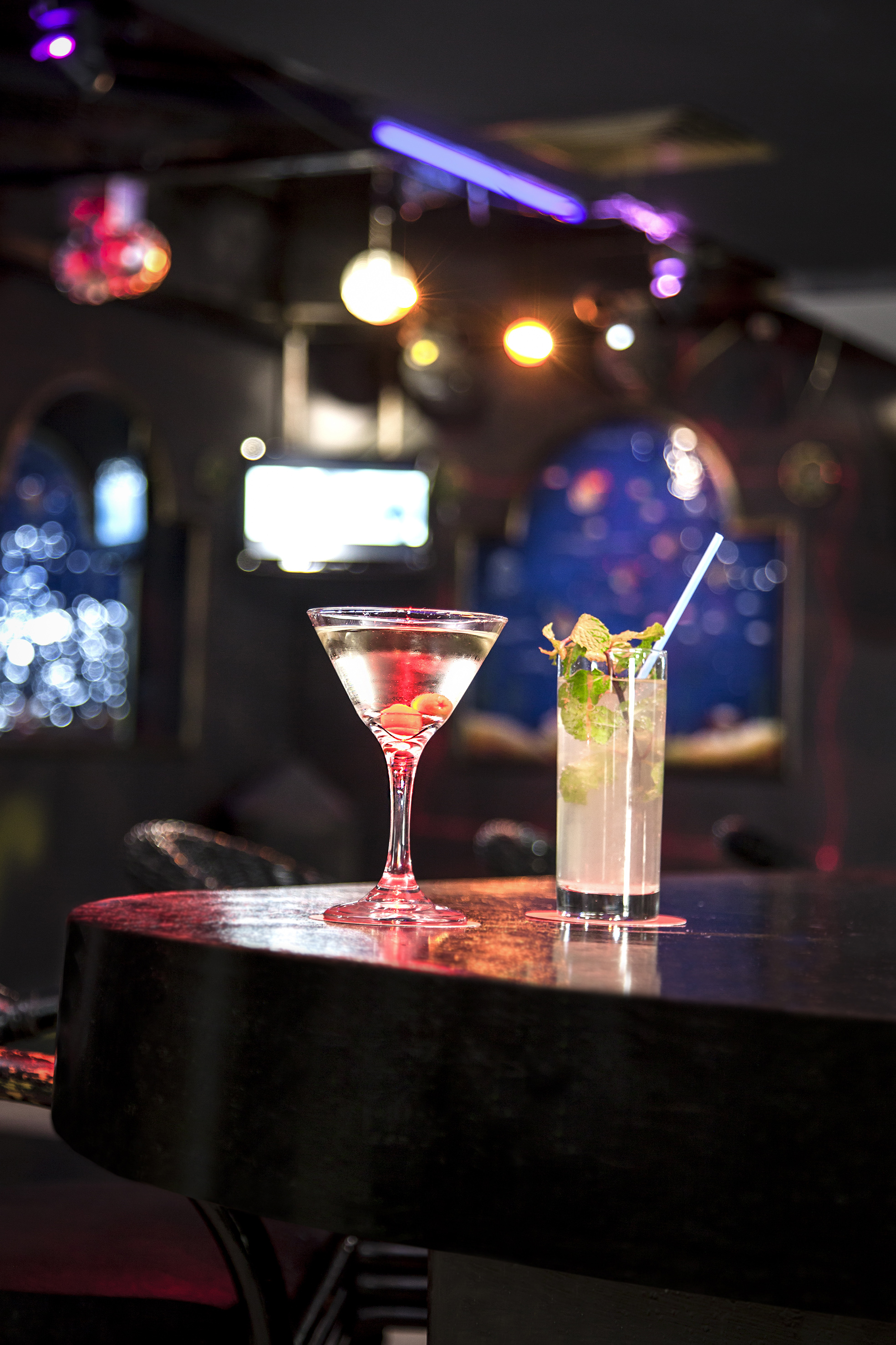 a glass of liquid and a drink on a bar