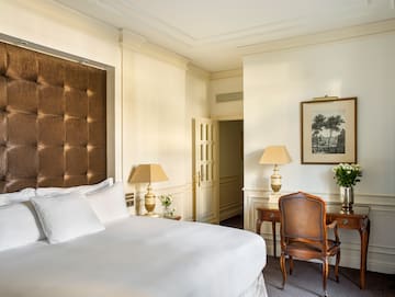 a bedroom with a bed and chairs