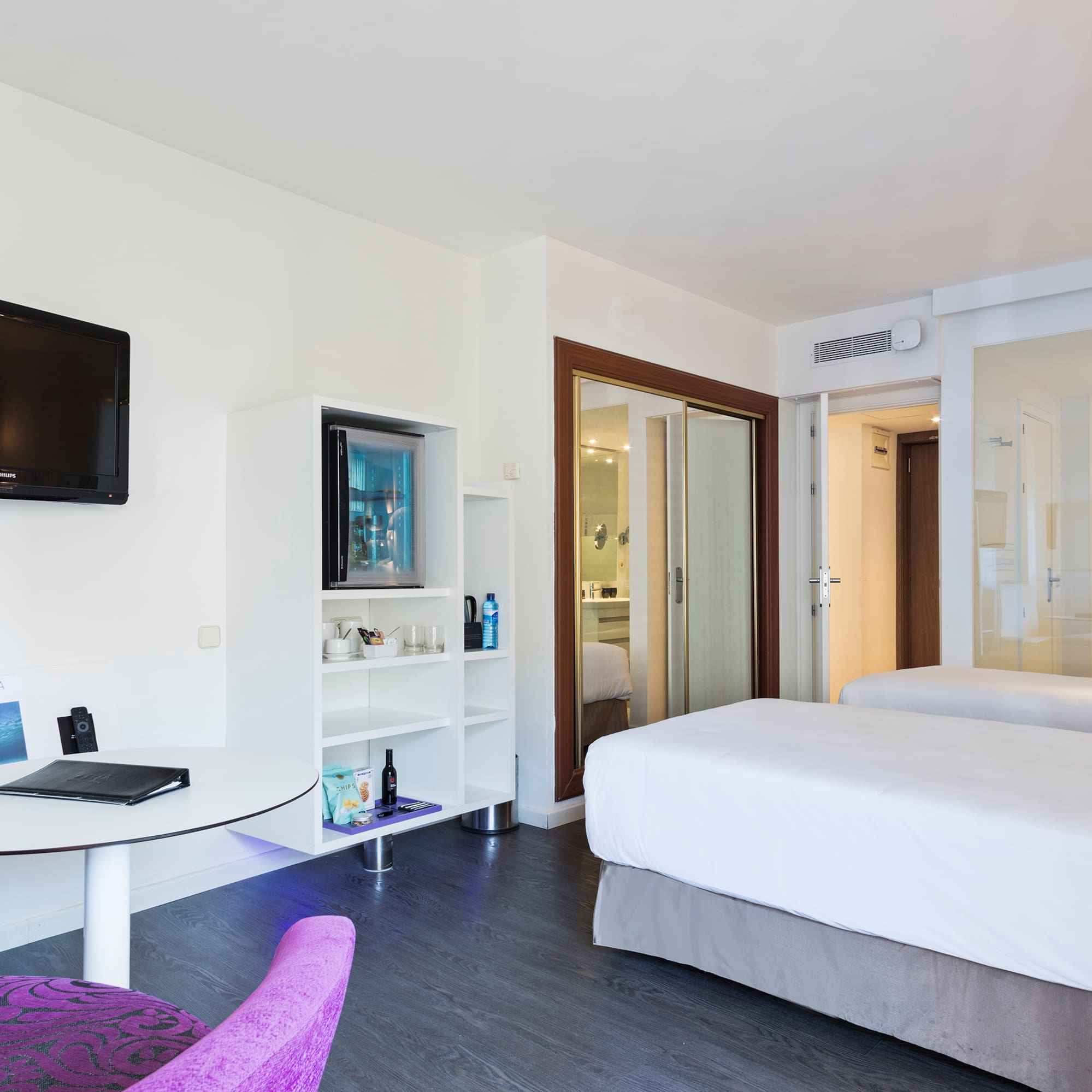 a room with two beds and a television