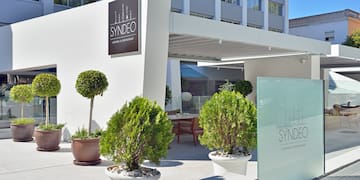 a building with a sign and plants in pots