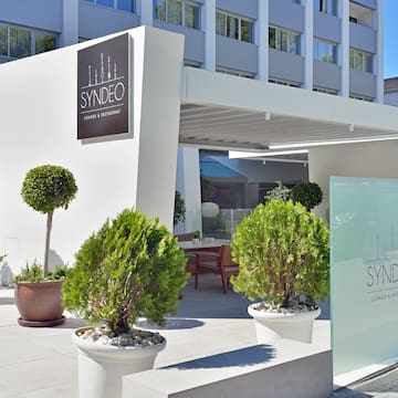 a building with a sign and plants in pots