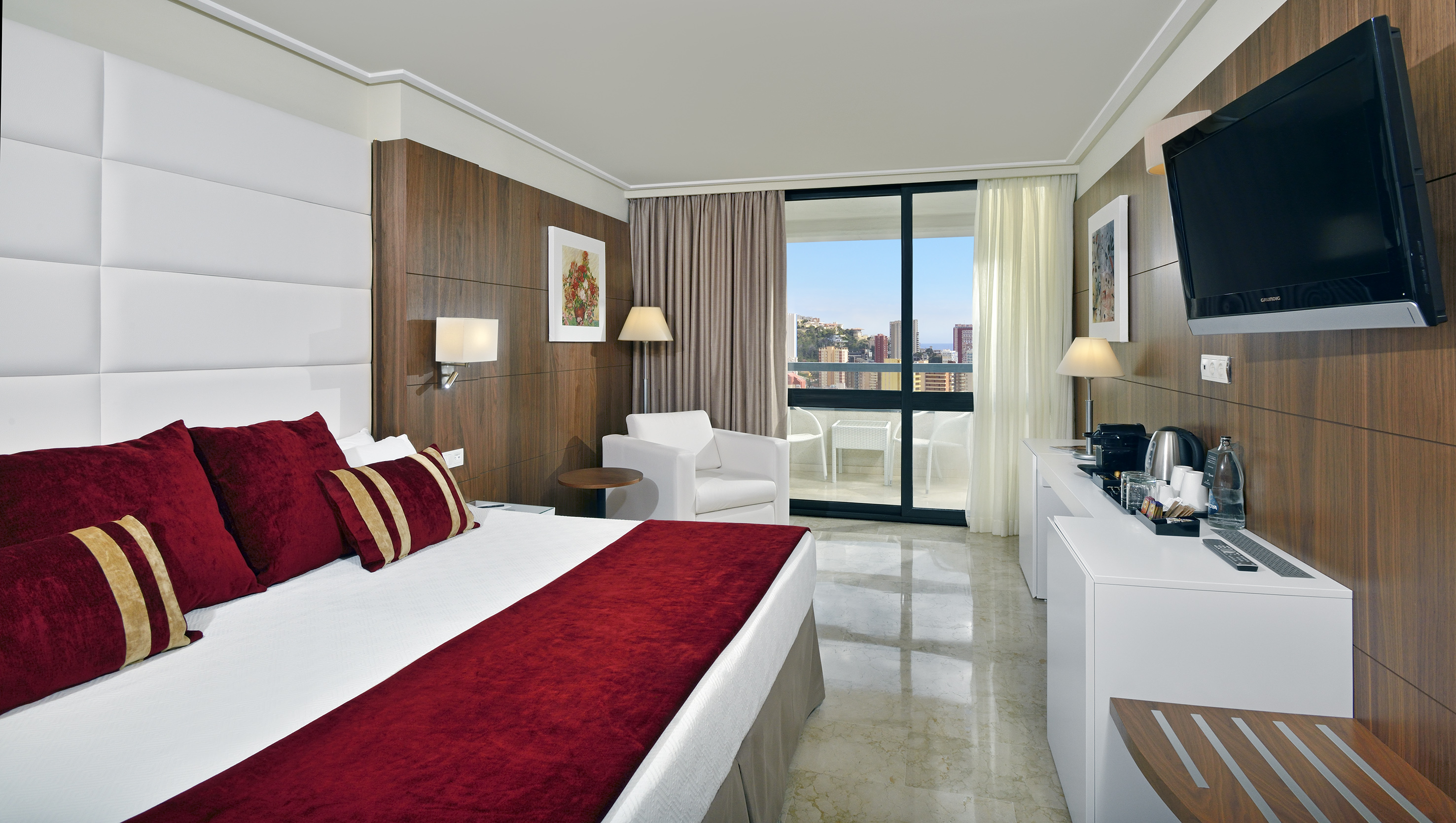 Luxury hotel room with king bed, balcony city view, wood accents.