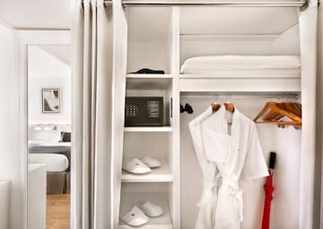 a white robe on swingers in a closet