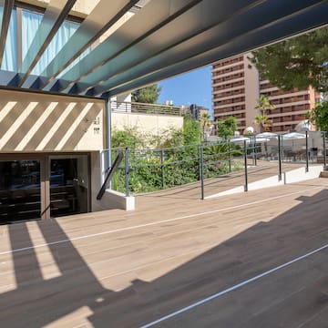 a wooden deck with a railing and trees in the background