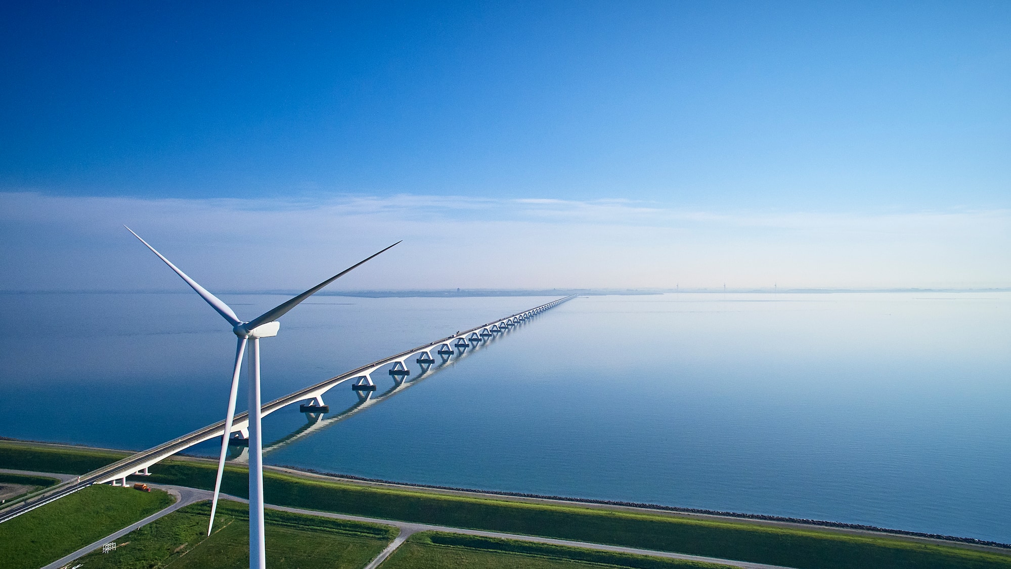 a wind turbines on a bridge over water