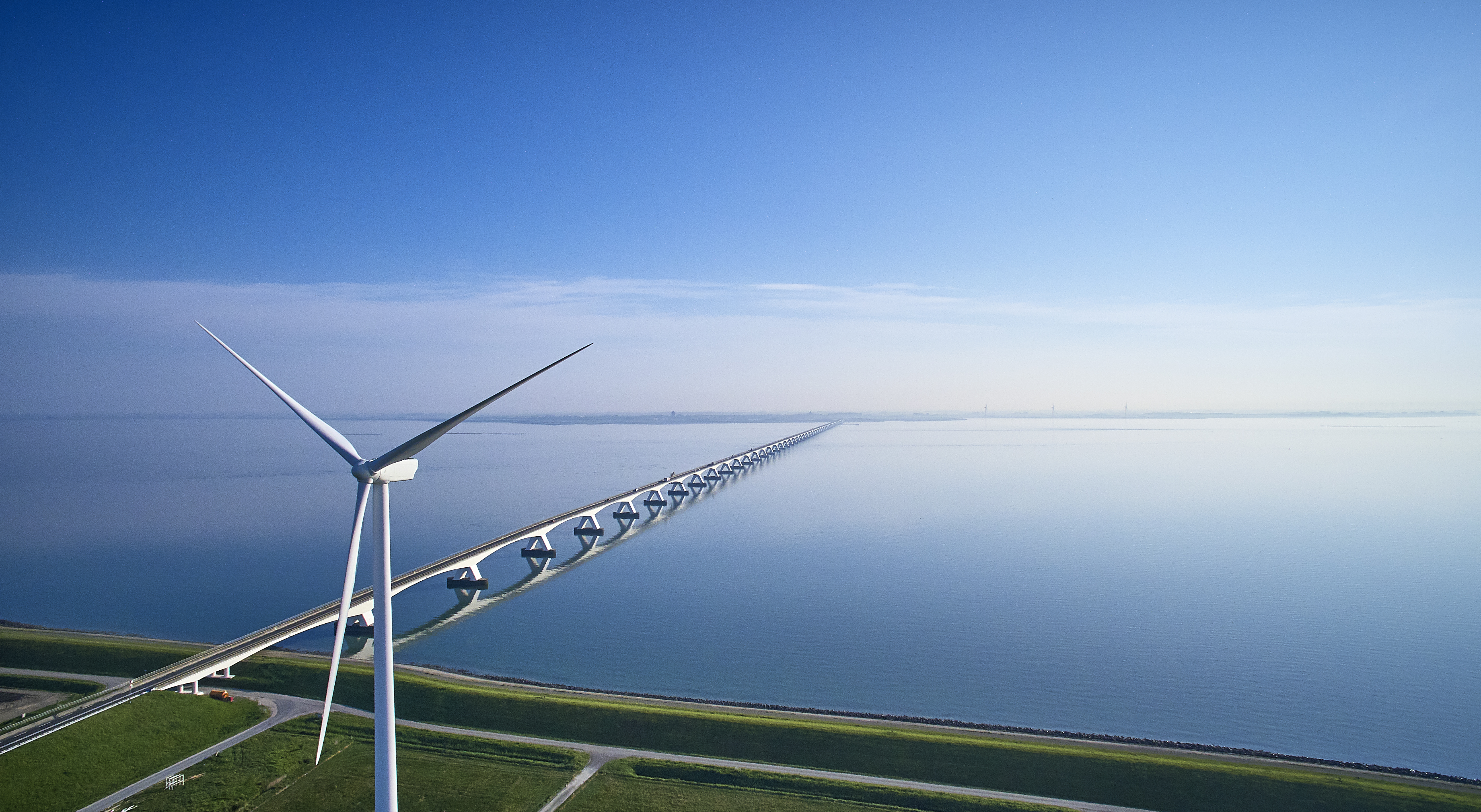 a wind turbines on a bridge over water