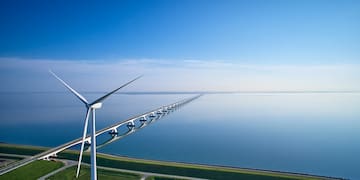 a wind turbines on a bridge over water
