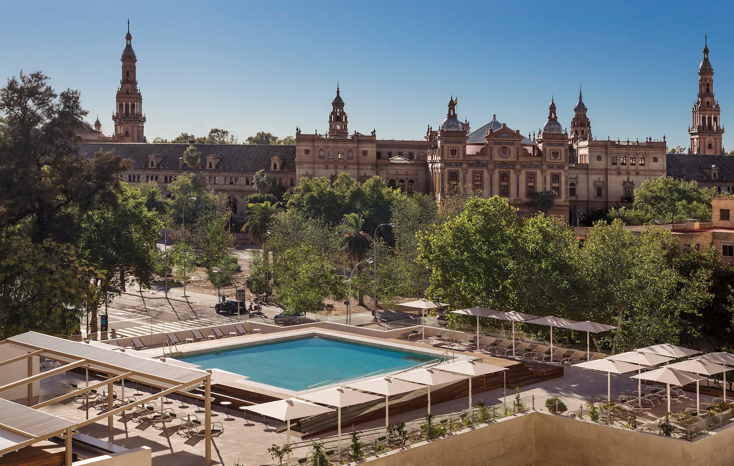 a pool in a courtyard with trees and a building in the background