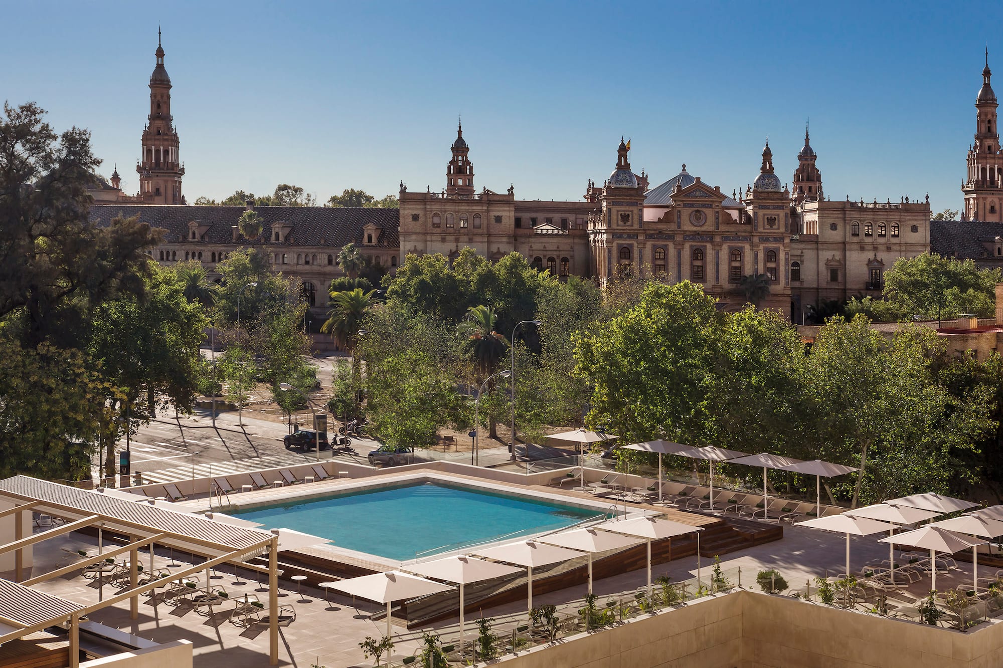 a pool in a courtyard with trees and a building in the background