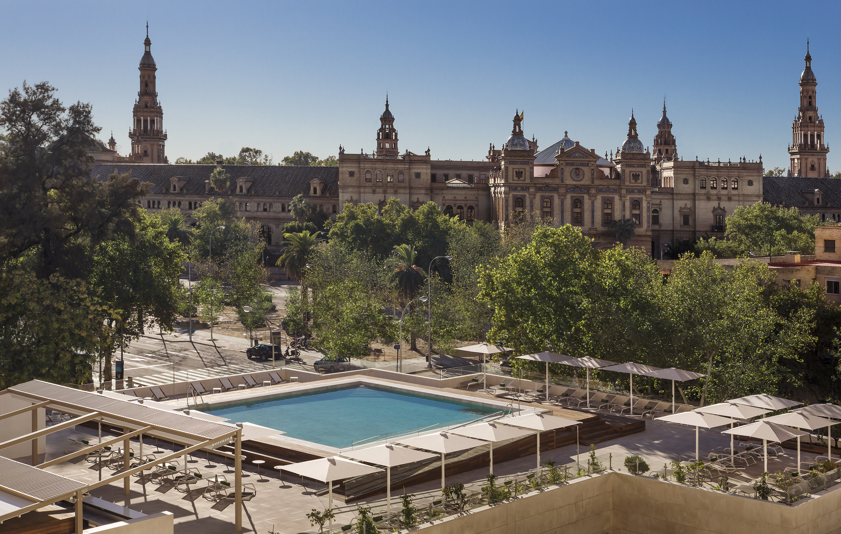 a pool in a courtyard with trees and a building in the background
