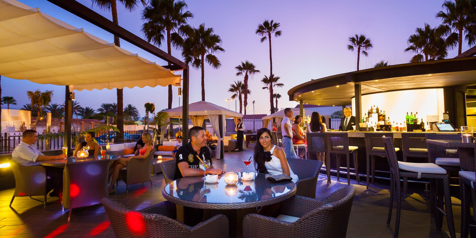 a group of people sitting at a table with tables and chairs
