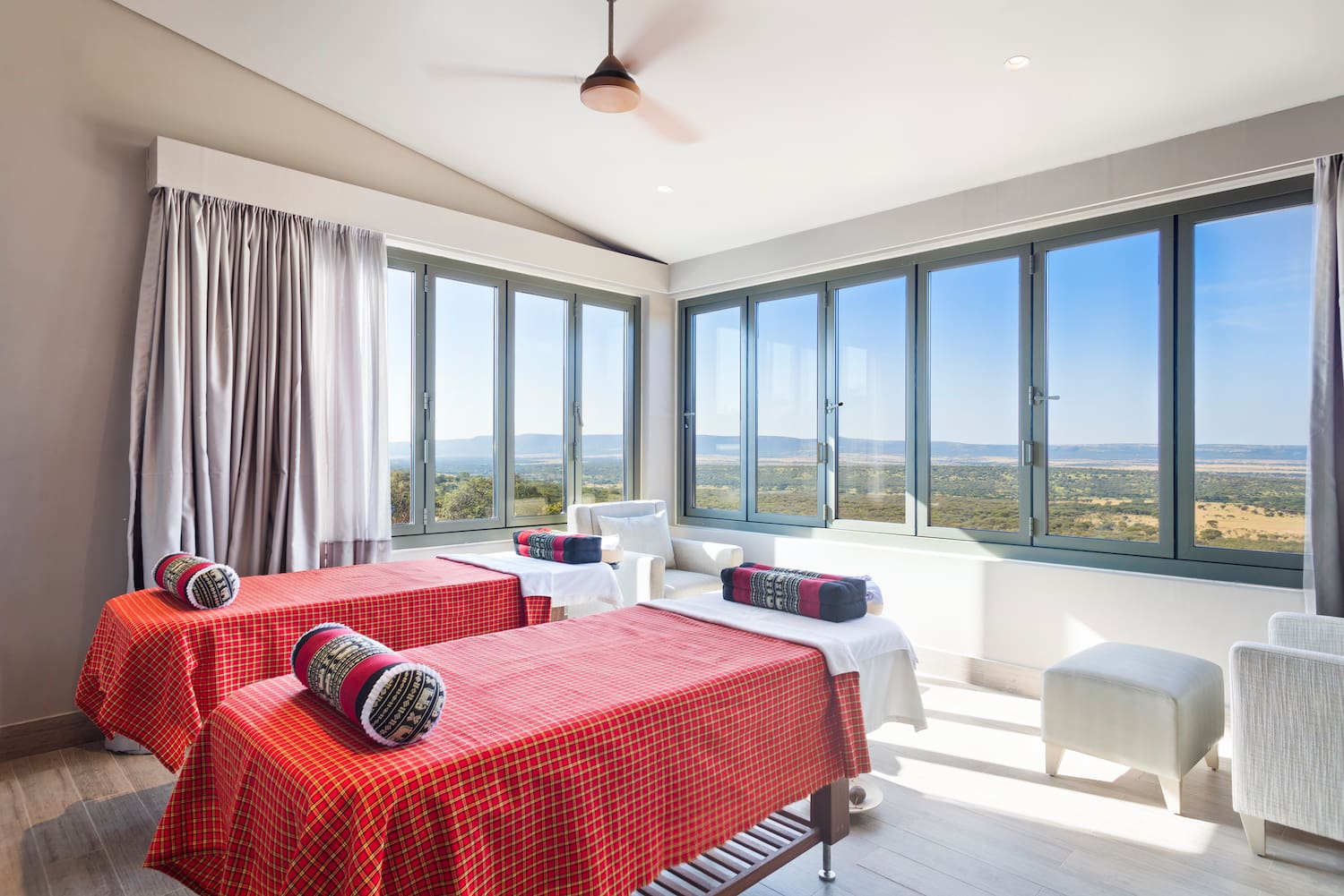 a room with red and white beds and windows