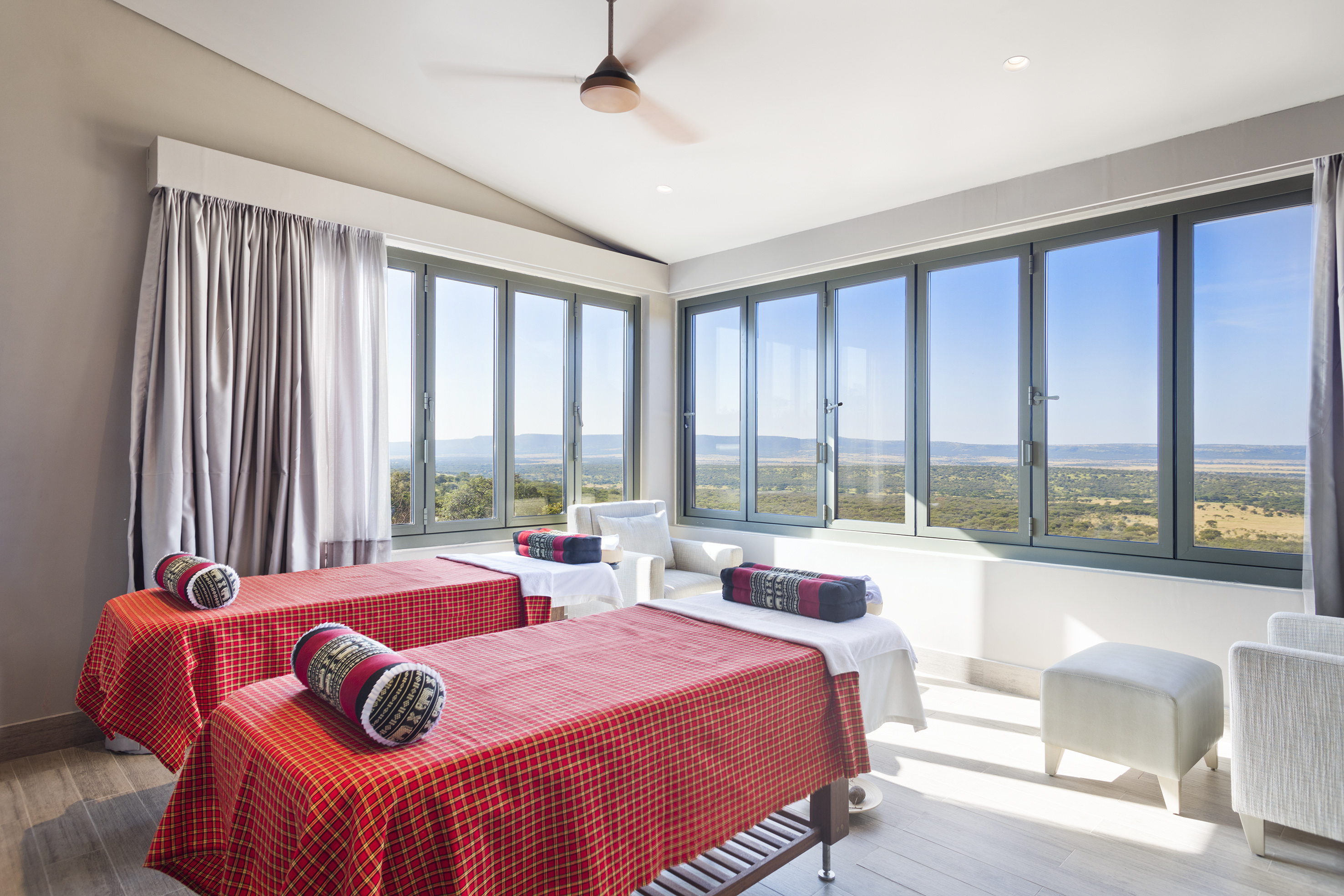 a room with red and white beds and windows