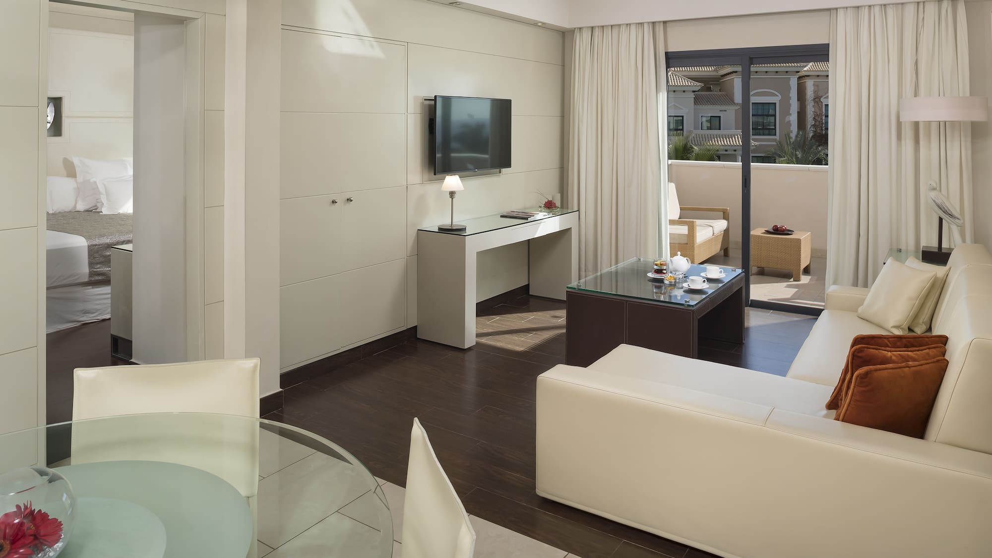 a living room with a glass table and a television