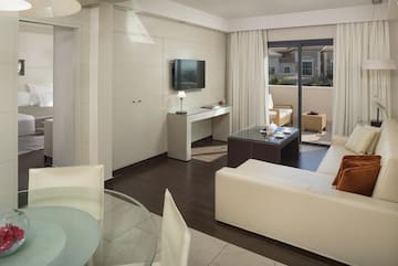 a living room with a glass table and a television.