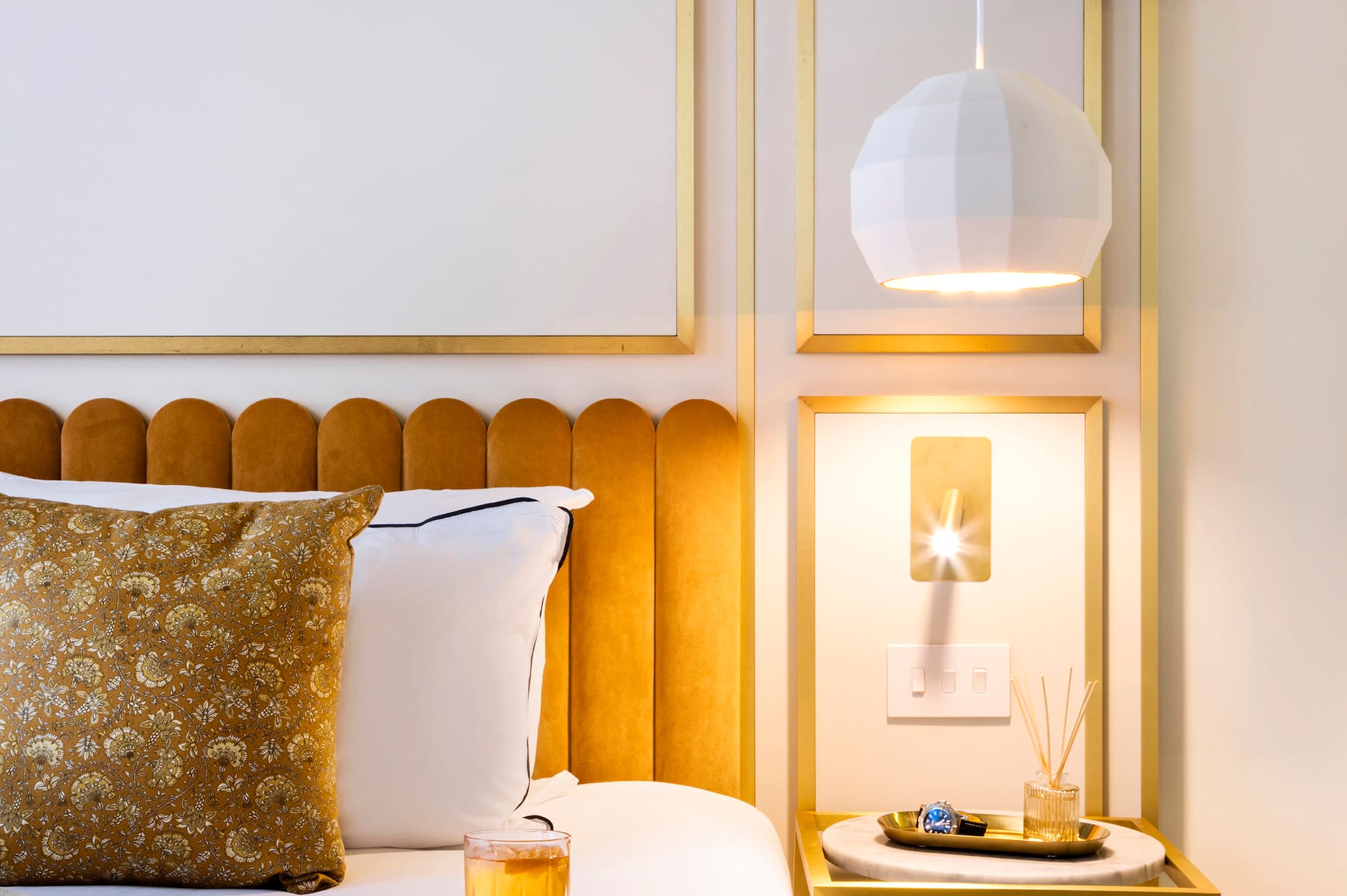 a bed with a tray of liquid and a glass of liquid on it