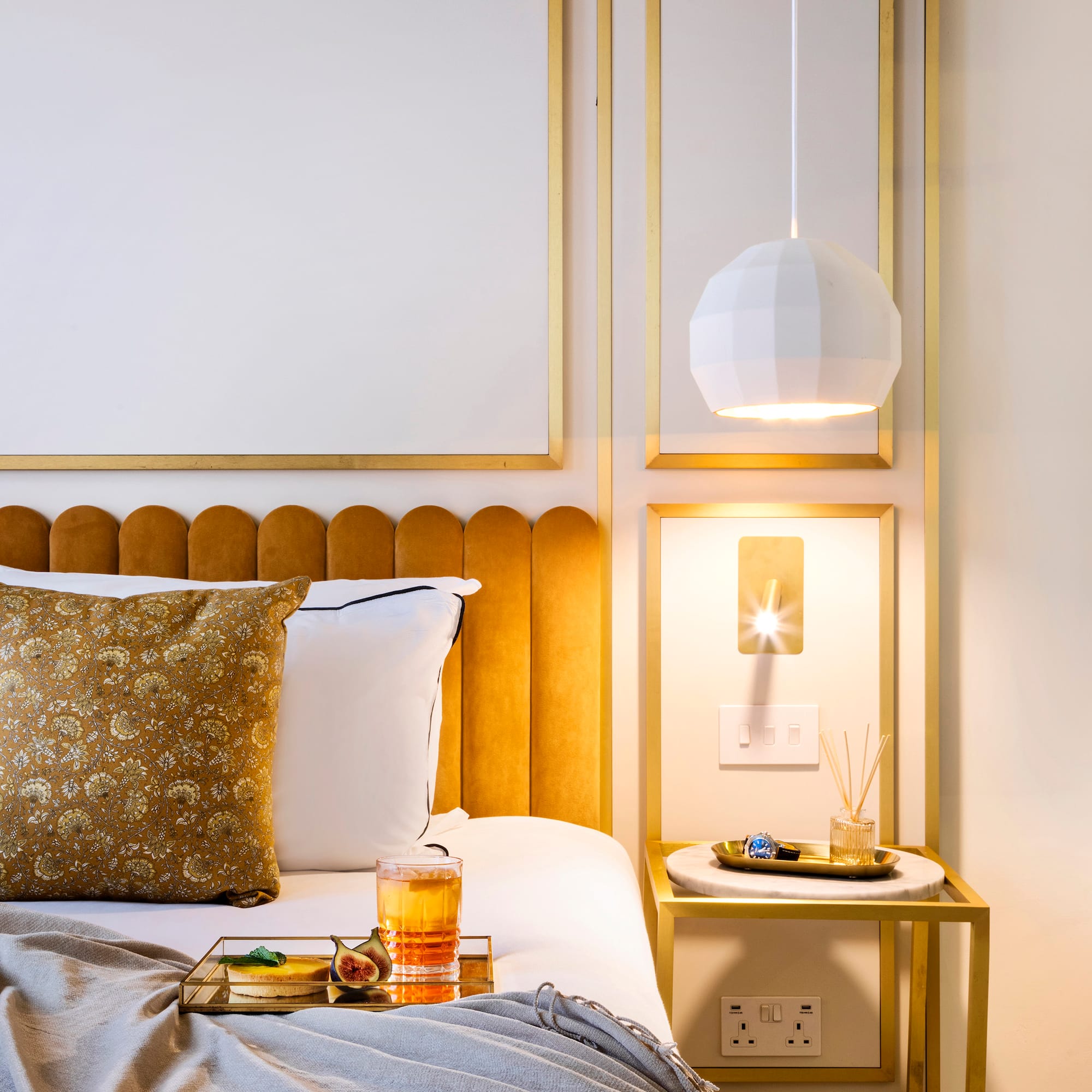 a bed with a tray of liquid and a glass of liquid on it