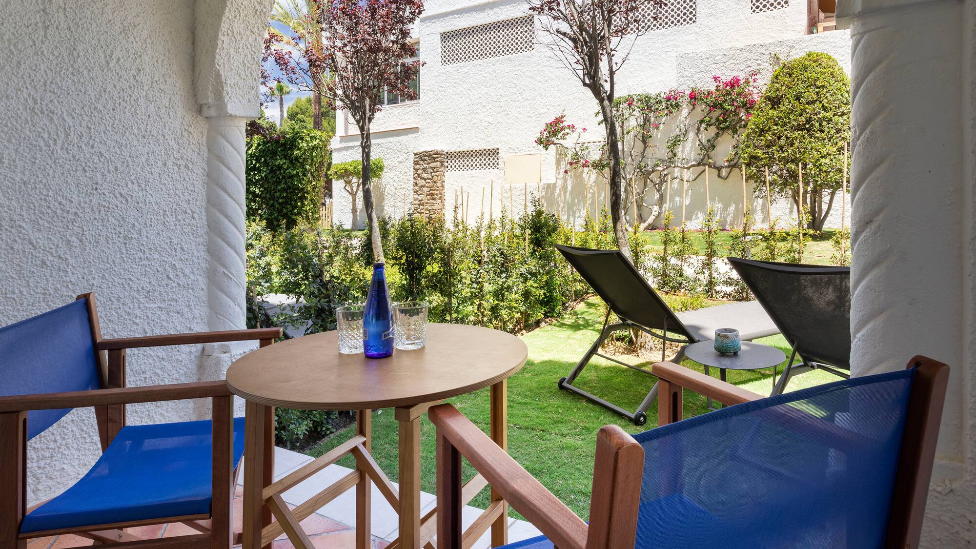 a table and chairs outside with a building in the background